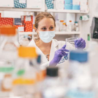 A scientists studies a sample in a lab